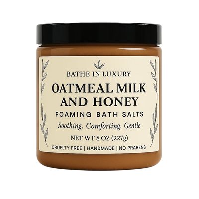 Jar of oatmeal milk and honey foaming bath salts with a black lid on a white background.