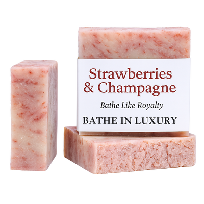 Three bars of 'Strawberries & Champagne' soap with a packaging box on a white background.